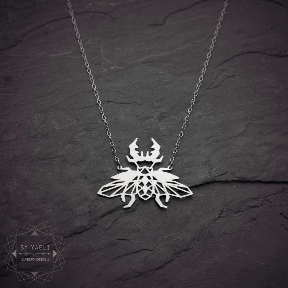 Beetle necklace geometric insect jewelry silver origami beetle pendant insect necklace 3 Beetle necklace a silver geometric necklace with a beetle pendant on it